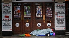 A rough sleeper rests at the entrance of theatre, closed due to the COVID-19 pandemic in London on Monday, February 8, 2021. 