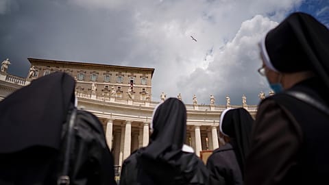 Nuns watch Pope Francis as he recites the Regina Caeli noon prayer from the window of his studio overlooking St.Peter's Square, at the Vatican, Sunday, April 18, 2021.