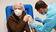 A health worker administers a dose of the Moderna COVID-19 vaccine to a man in his 80s at a vaccine center in Rome's Auditorium, Monday, Feb. 15, 2021.