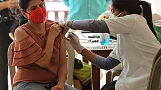 A woman reacts as she receives the AstraZeneca vaccine for COVID-19 at an apartment building in Bengaluru, India, Saturday, April 24, 2021.