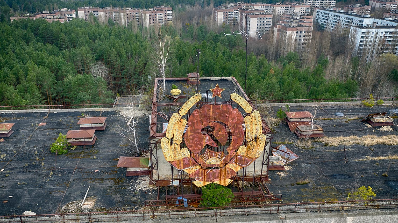 The rusty emblem of the Soviet Union is seen over the ghost town of Pripyat close to the Chernobyl nuclear plant, Ukraine, Thursday, April 15, 2021. 