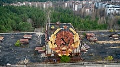 The rusty emblem of the Soviet Union is seen over the ghost town of Pripyat close to the Chernobyl nuclear plant, Ukraine, Thursday, April 15, 2021. 