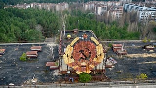 The rusty emblem of the Soviet Union is seen over the ghost town of Pripyat close to the Chernobyl nuclear plant, Ukraine, Thursday, April 15, 2021. 