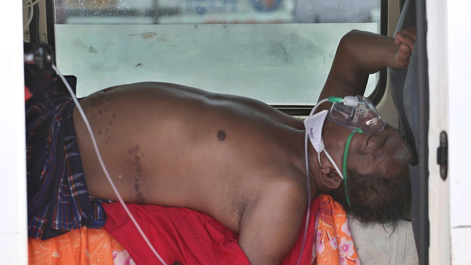 Um "doente covid" aguarda dentro de um veículo a admissão num hospital de Ahmedabad, Índia