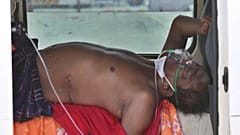 Um "doente covid" aguarda dentro de um veículo a admissão num hospital de Ahmedabad, Índia