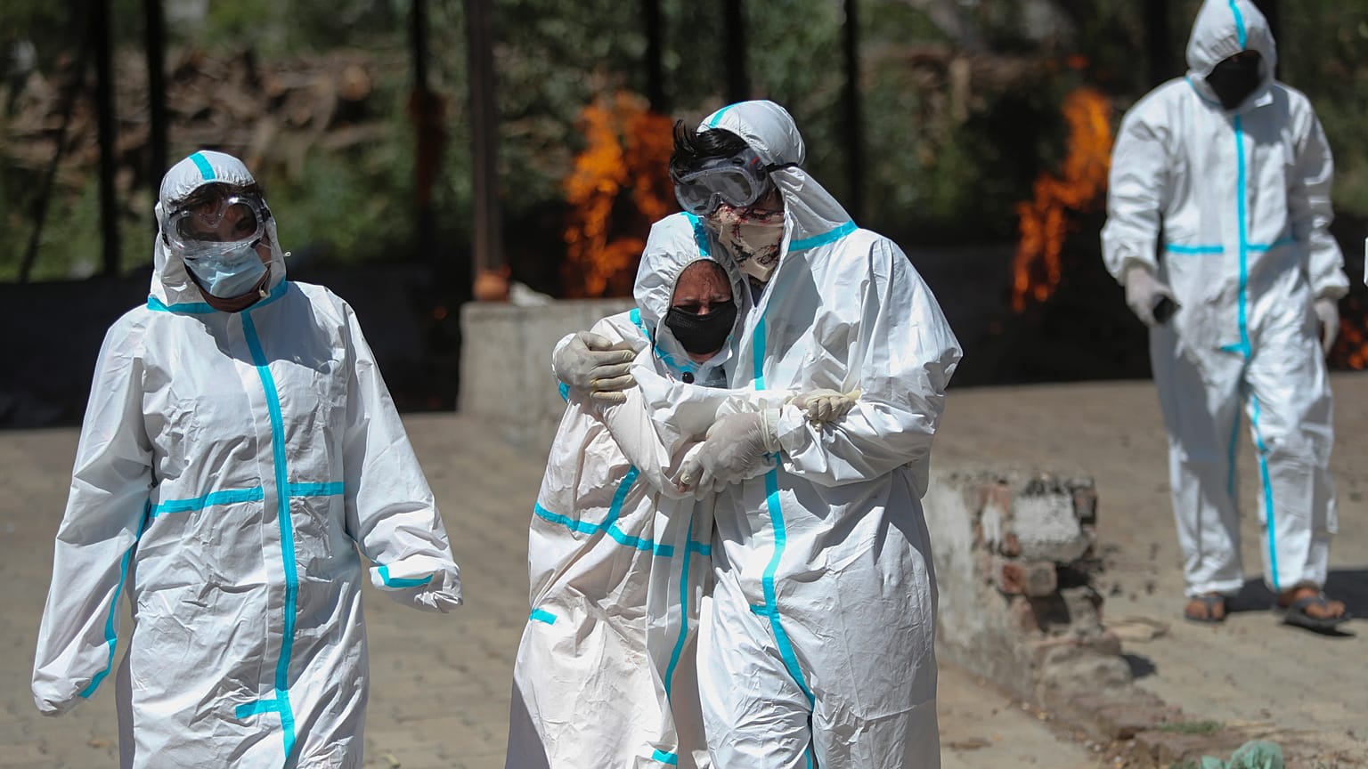 A relative of a person who died of COVID-19 is consoled by another during cremation in Jammu, India, Sunday, April 25, 2021. 