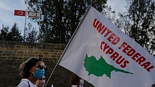 Kıbrıs'ın birleşmesi için düzenlenen gösteride elinde 'Birleşik Federal Kıbrıs' yazılı pankart taşıyan barış yanlısı bir aktivist