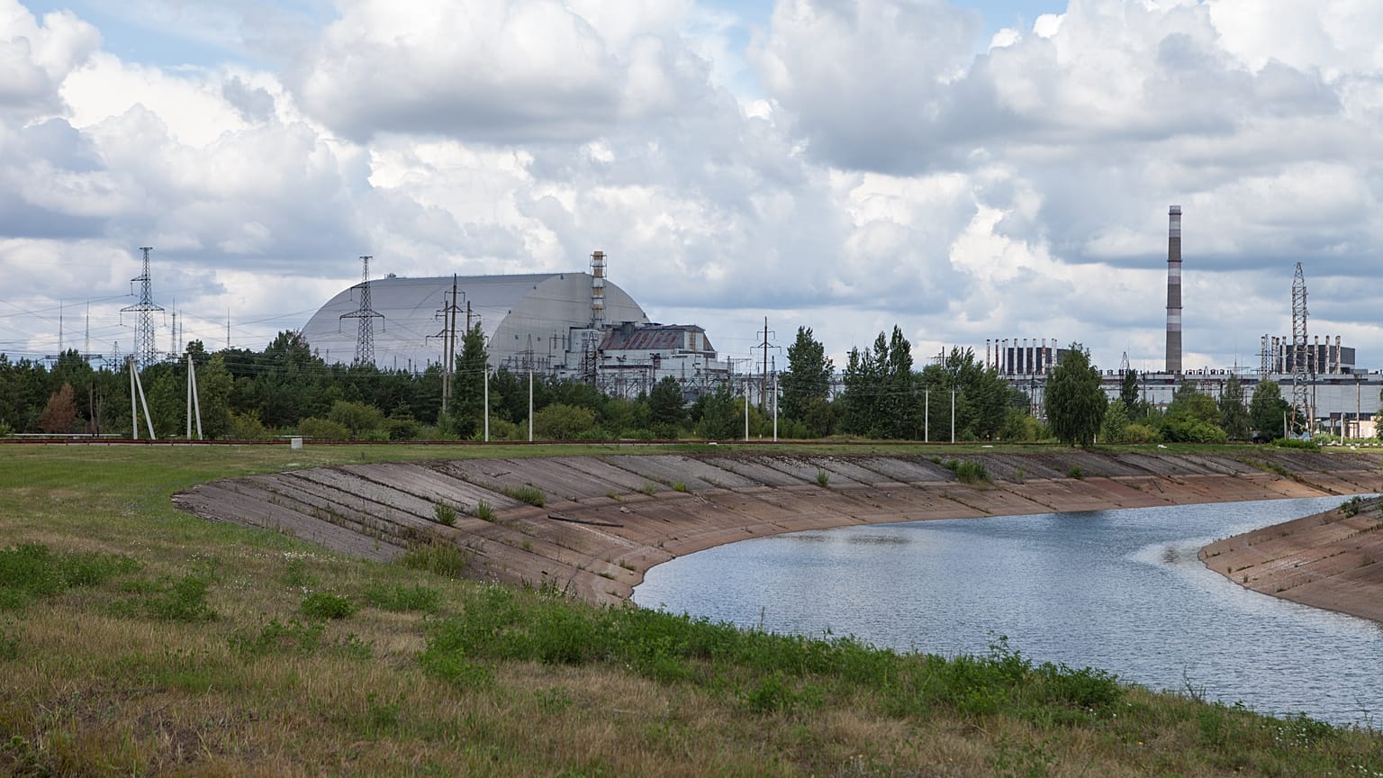 The view over the cooling pond of the Chernobyl nuclear power plant and reactor No. 4, covered with the protective shield. 