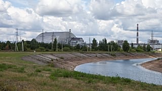 The view over the cooling pond of the Chernobyl nuclear power plant and reactor No. 4, covered with the protective shield.