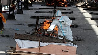 رجل هندي يؤدي طقساً دينياً في وداع أحد أقربائه