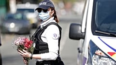 Une policière tient des fleurs que des habitants de Rambouillet lui ont donné, pour qu'il soit déposé sur les lieux de l'assassinat de Stéphanie Monfermé
