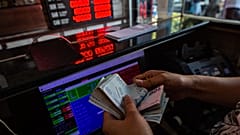 A currency exchange office worker counts Turkish Lira banknotes