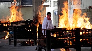 Flames rise from cremation pyres of victims of a fire that broke out in Vijay Vallabh COVID-19 hospital, at Virar, near Mumbai, India, Friday, April 23, 2021.