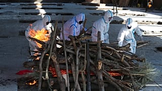 Familiares de uma vítima da Covid realizam rituais fúnebres antes da cremação