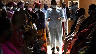 Numbers are handed out to people waiting to receive the AstraZeneca COVID-19 vaccine at Ndirande Health Centre in Blantyre Malawi on March 29, 2021.