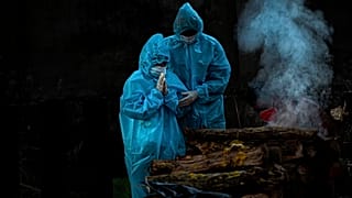 Un fils de 9 ans pratique les rites funéraires pour son père décédé du Coronavirus, Gauhati, Inde, le 16 décembre 2020