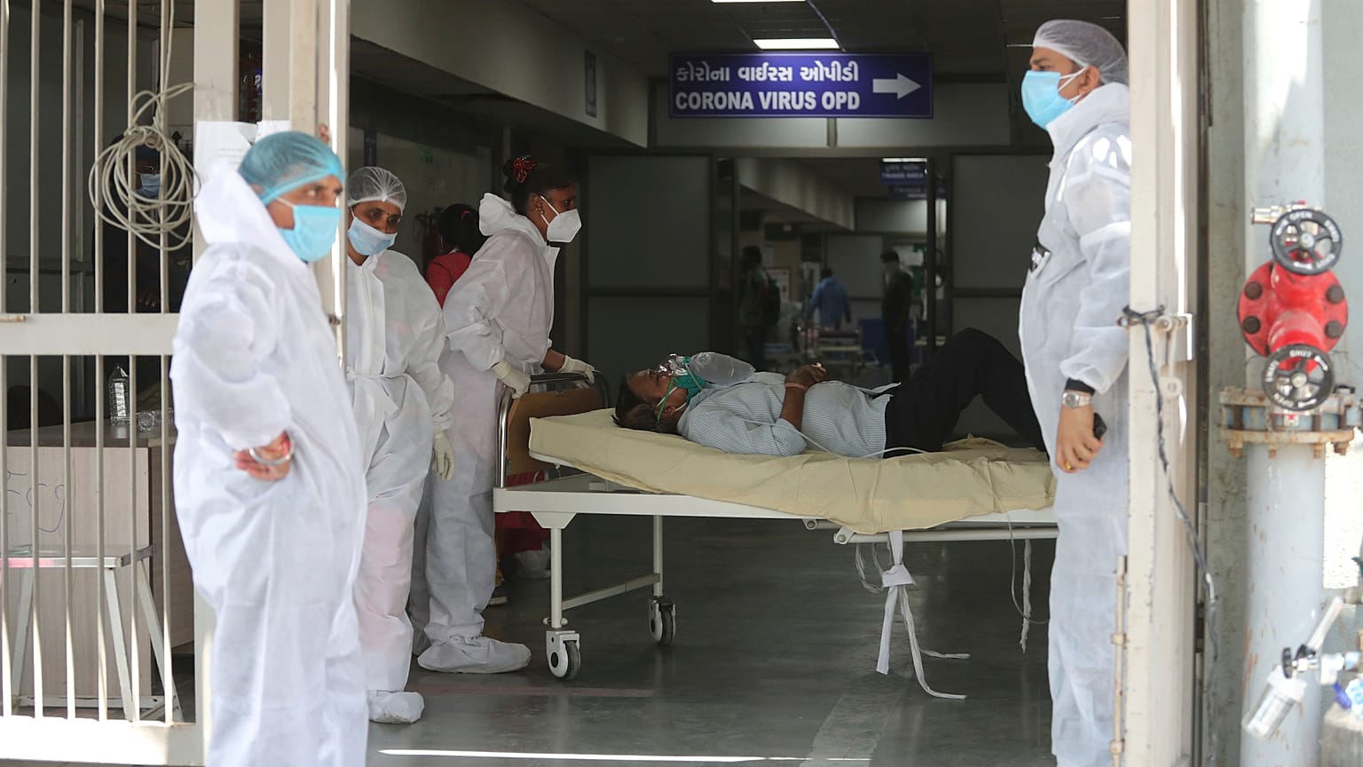 Health workers carry a patient into a dedicated COVID-19 hospital in Ahmedabad, India, on April 15, 2021.