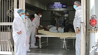 Health workers carry a patient into a dedicated COVID-19 hospital in Ahmedabad, India, on April 15, 2021.