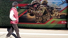 Мужчина в маске проходит мимо графити. 