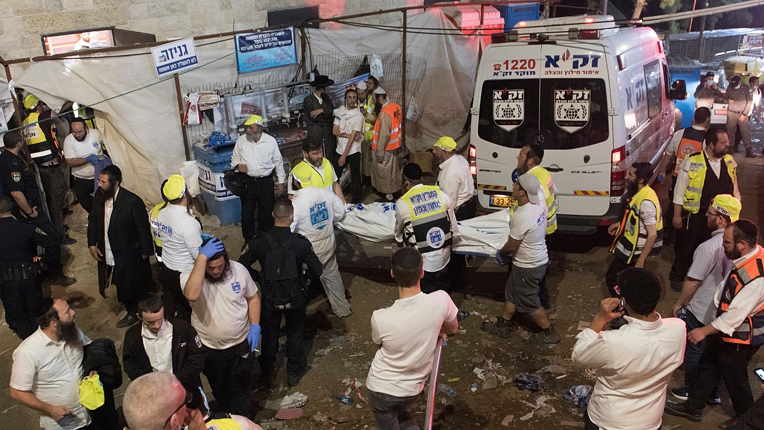 Israeli security officials and rescuers carry a body of a victim who died during a Lag Ba'Omer celebrations at Mt. Meron in northern Israel, Friday, April 30, 2021.