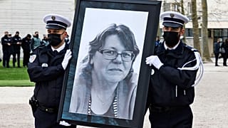 French police officers carry the portrait of Stephanie Monferme during the remembrance gathering in Rambouillet.