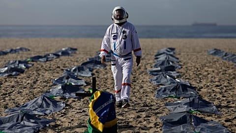 Tercio Galdino walks amid mock body bags representing COVID-19 victims on Copacabana beach.