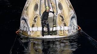Support teams work around the SpaceX Crew Dragon Resilience spacecraft shortly after it landed in the Gulf of Mexico.