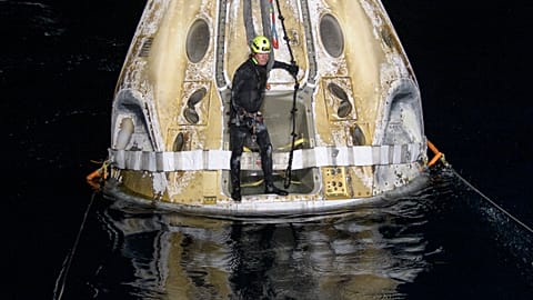 Support teams work around the SpaceX Crew Dragon Resilience spacecraft shortly after it landed in the Gulf of Mexico.