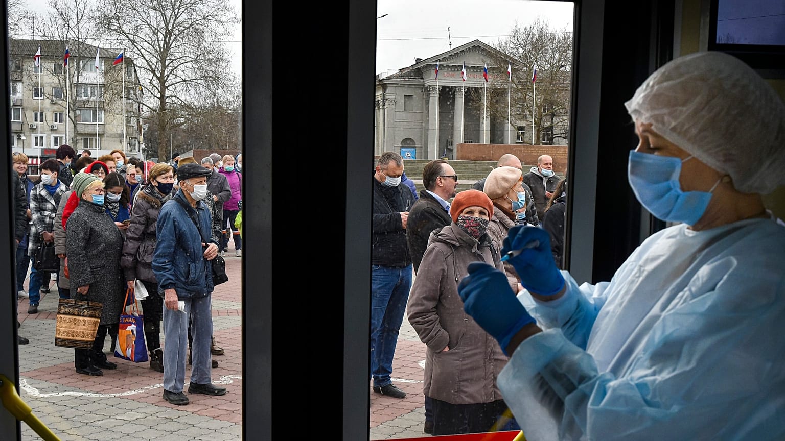 A Russian medical worker prepares a shot of Russia's Sputnik V coronavirus vaccine  as people queue for the jab in Simferopol, Crimea, April 13, 2021. 