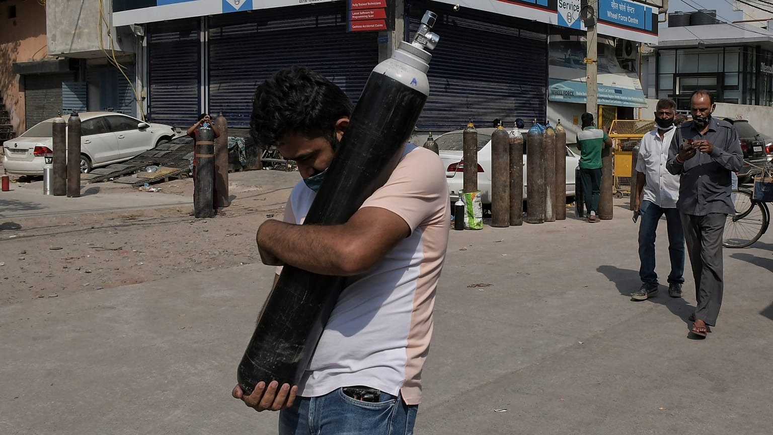 رجل يحمل اسطوانة أكسيجين ليملأها فيما مصابون بكوفيدـ19 ينتظرون في طابور في نيودلهي. 2021/05/03