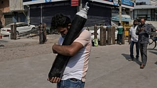 رجل يحمل اسطوانة أكسيجين ليملأها فيما مصابون بكوفيدـ19 ينتظرون في طابور في نيودلهي. 2021/05/03