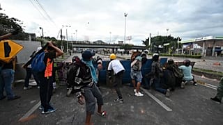 Demonstrators throwing objects towards riot police