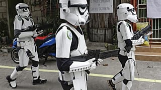 Miembros de un grupo de jóvenes con disfraces de La Guerra de las Galaxias entretienen a los lugareños a lo largo de una carretera en Malabon, Metro Manila