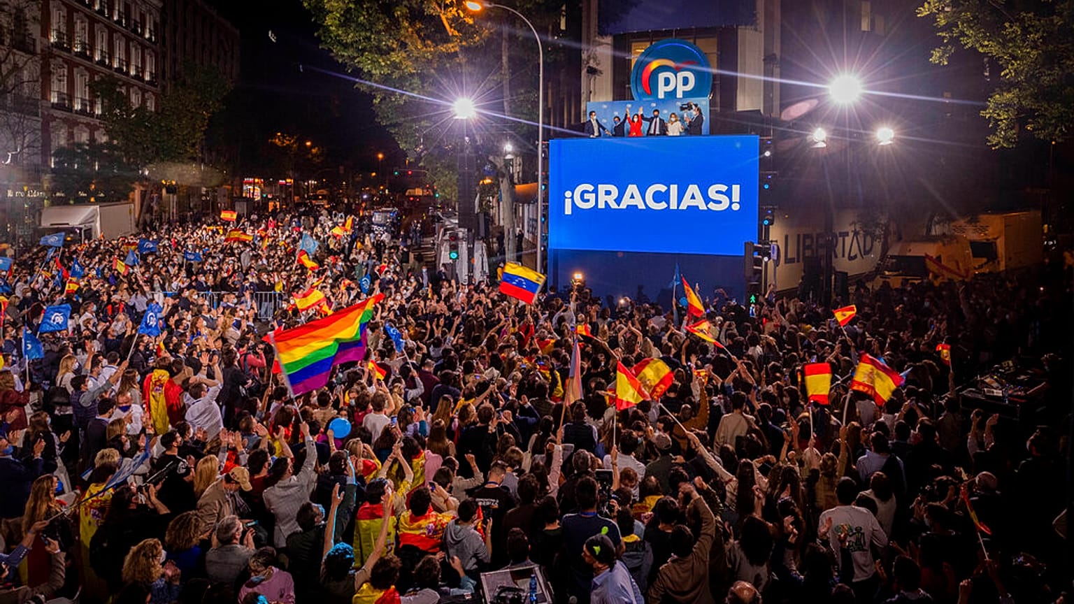 People gather outside the conservative Popular Party's regional headquarters in Madrid, Spain
