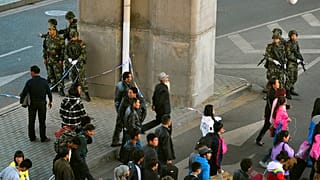 Doğu Türkistan'ın başkenti Urumçi'de bir metro durağı çevresinde görev yapan Çinli paramiliter güçler (arşiv) 
