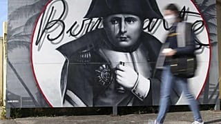 Eine Frau geht an einem Bild von Napoleon Bonaparte in Korsika vorbei