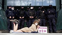 Policemen guard Poland's Supreme Court as a protester lies on the pavement in Warsaw, Poland, on Thursday, April 22, 2021.