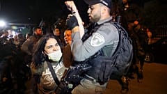 A Palestinian woman scuffles with Israeli border police officer during a protest against the planned evictions of Palestinian families in the Sheikh Jarrah
