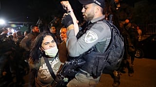 A Palestinian woman scuffles with Israeli border police officer during a protest against the planned evictions of Palestinian families in the Sheikh Jarrah