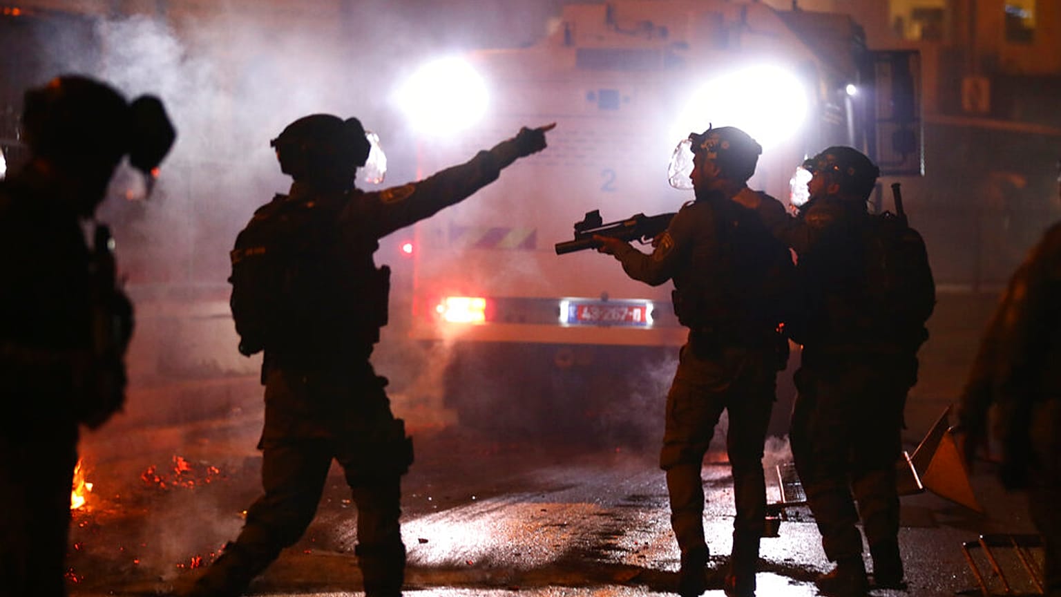 Israeli police officers fire stun grenades towards Palestinian demonstrators during clashes at Damascus Gate just outside Jerusalem's Old City