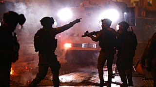 Israeli police officers fire stun grenades towards Palestinian demonstrators during clashes at Damascus Gate just outside Jerusalem's Old City