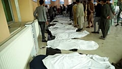 Afghan men try to identify the dead bodies at a hospital after a bomb explosion near a school west of Kabul, Afghanistan, Saturday, May 8, 2021.