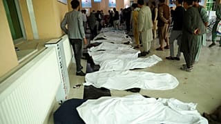 Afghan men try to identify the dead bodies at a hospital after a bomb explosion near a school west of Kabul, Afghanistan, Saturday, May 8, 2021.