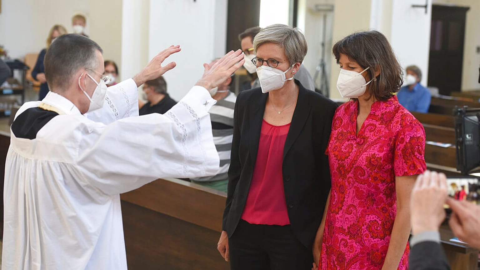 Vikar Wolfgang Rothe, segnet Christine Walter und Almut Muenster während eines Gottesdienstes in München, 9. Mai 2021