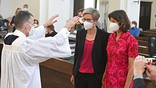 Vikar Wolfgang Rothe, segnet Christine Walter und Almut Muenster während eines Gottesdienstes in München, 9. Mai 2021