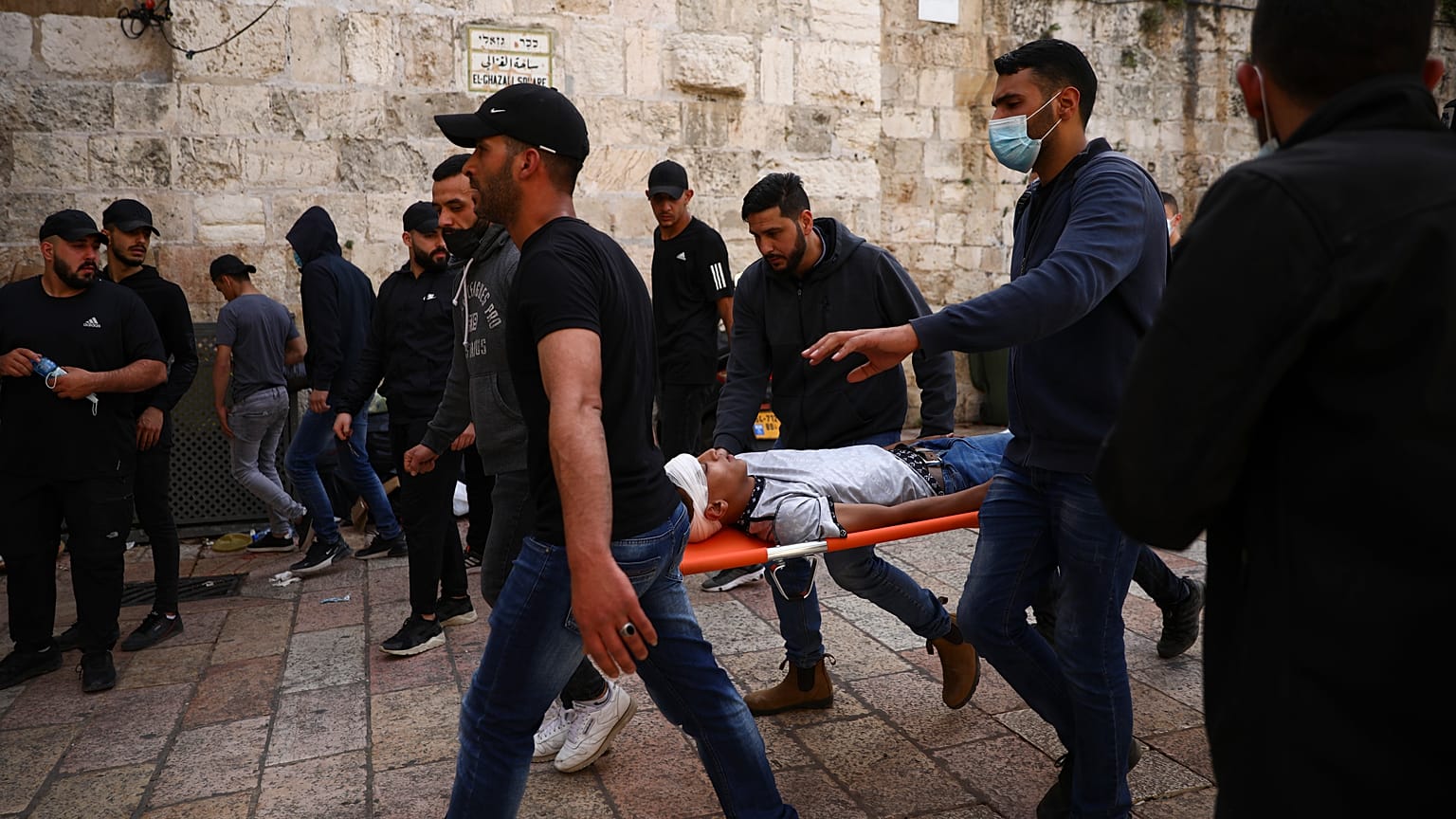 فلسطينيون بحملون متظاهرا مصابا خلال مواجهات مع قوات الأمن الإسرائيلية قرب باب الأسباط، البلدة القديمة بالقدس، الإثنين، 10 مايو، 2021