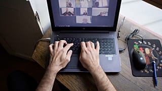A man works from home as multinationals seek to make remote work permanent.