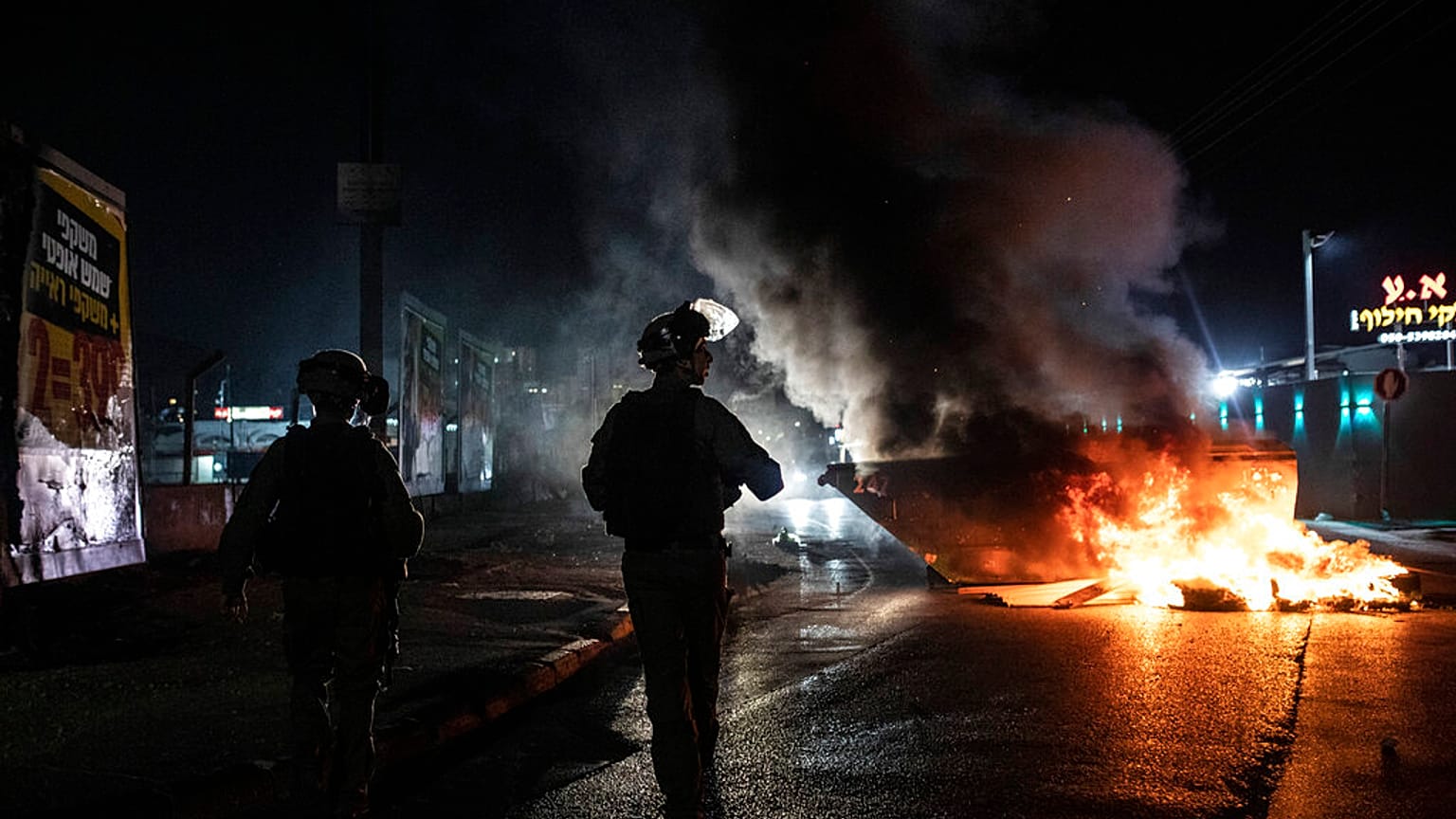 Firefighters inspect destroyed buildings after it was hit by Israeli airstrikes, in Gaza City