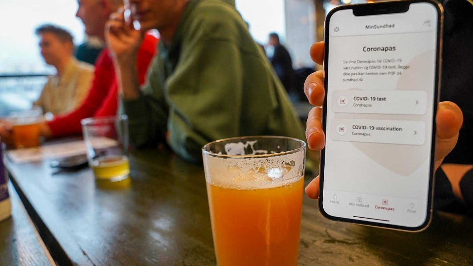 Kunde zeigt Corona-Pass in einer dänischen Kneipe