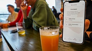 Kunde zeigt Corona-Pass in einer dänischen Kneipe
